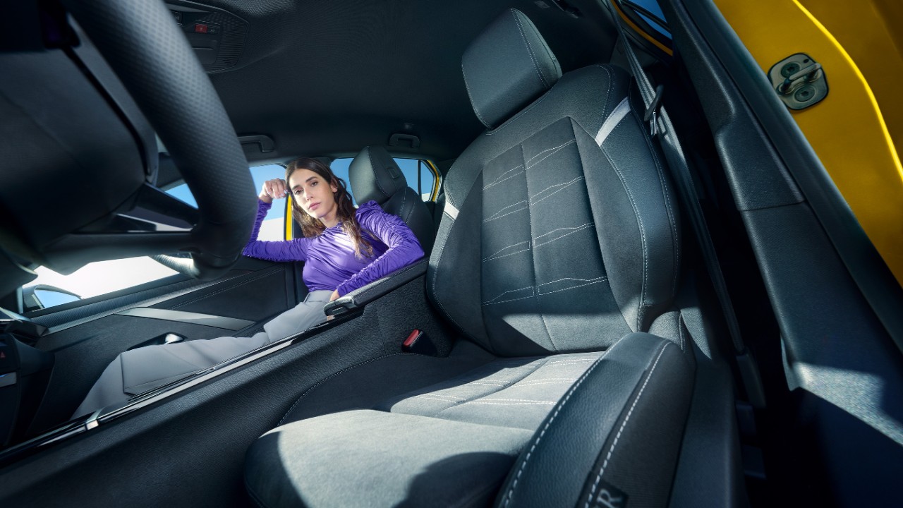 Sièges avant noirs d'une Opel Astra Electric avec une femme assise sur le siège passager.